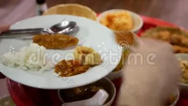 有选择的重点是北泰式晚餐，汉托克晚餐，食物被舀起来放在一个游客的盘子里